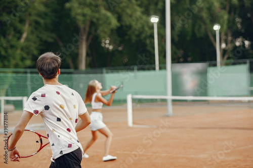 Young couple on tennis court. Two tennis players in a sport clothes. © hetmanstock2