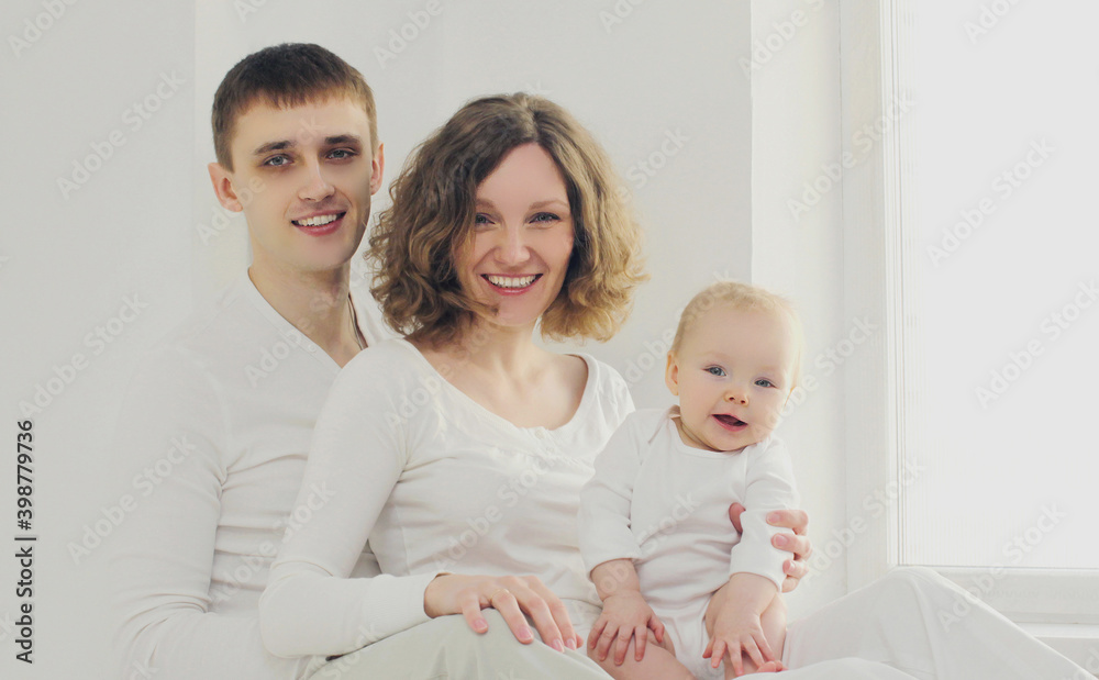 Family portrait of happy smiling mother, father and baby together over a white background Family portrait of happy smiling mother, father and baby together over a white background