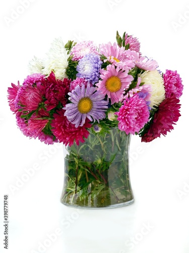 multicolor asters flowers in glass vase close up