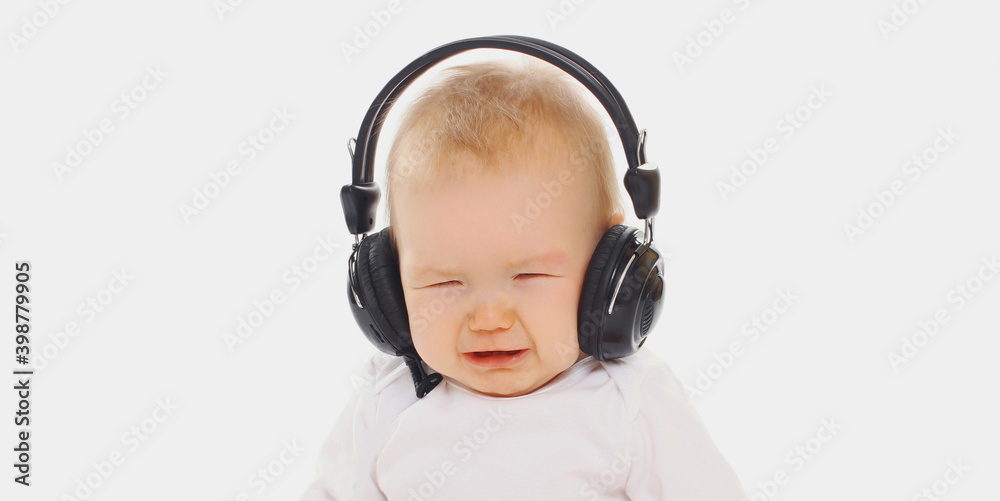 Portrait close up of baby crying in headphones on a white background Portrait close up of baby crying in headphones on a white background