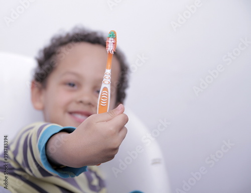 little boy brushing his teeth with a tooth brush stock image with grey background stock photo