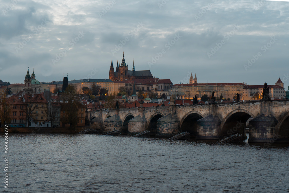 old prague castle and charles bridge and st. vita church lights from street lights are reflected on the surface of the vltava river in the center of prague at night in the czech republic