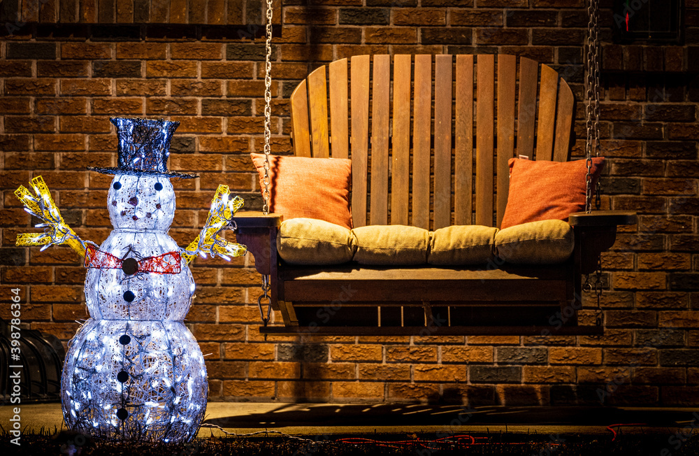 Illuminated outdoor snowman decoration on front porch