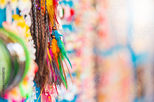 Small colorful souvenirs hanging on a display wall at a market in a tourist attraction.