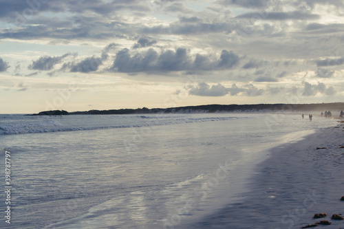 a beach with people walking on it