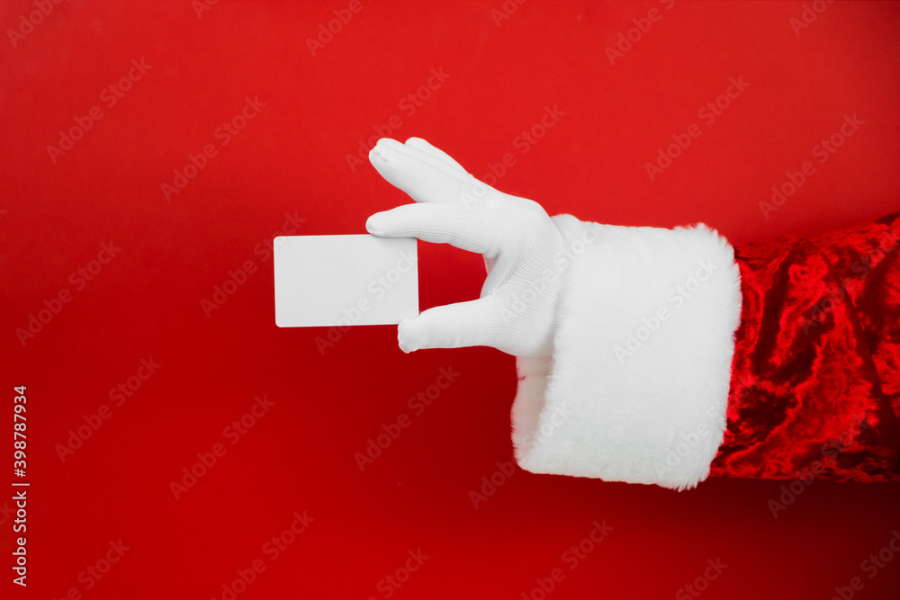 Santa Claus hand holding blank plastic credit card on red background ...