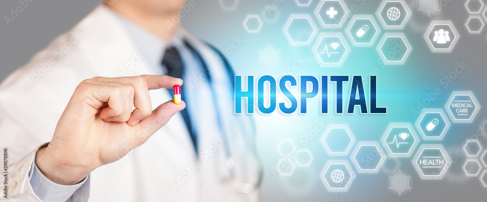 Close-up of a doctor giving you a pill with HOSPITAL inscription, medical concept Close-up of a doctor giving you a pill with HOSPITAL inscription, medical concept
