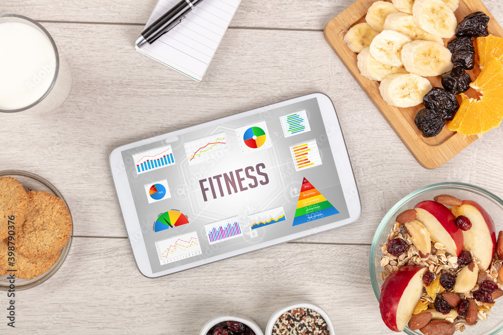 Organic food and tablet pc showing FITNESS inscription, healthy nutrition composition Organic food and tablet pc showing FITNESS inscription, healthy nutrition composition