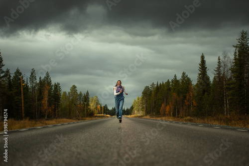 woman runs on a road in the autumn forest