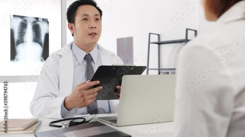 Wallpaper Mural Serious Asia male doctor in white medical uniform using clipboard is delivering great news talk discuss results or symptoms with female patient sitting at desk in health clinic or hospital office. Torontodigital.ca