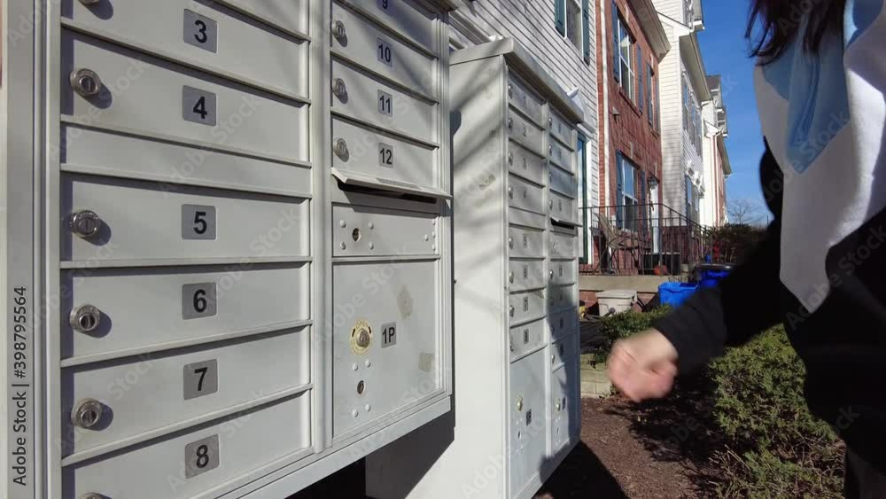 A woman is placing a letter she wishes to send in the outgoing box