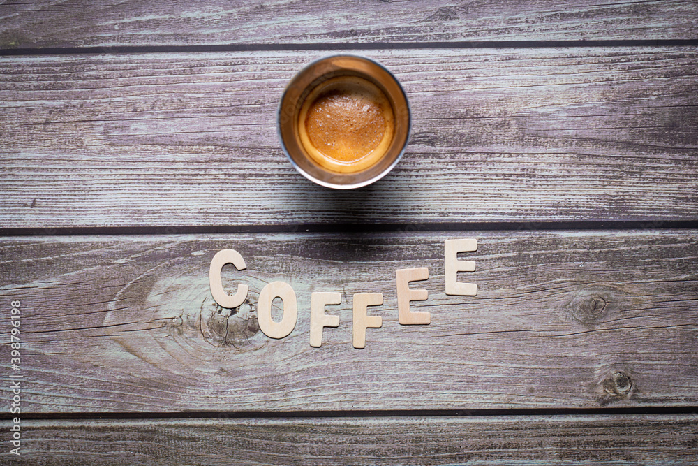 Coffee wooden letters on a wooden board with an espresso creamy coffee served on a cup Coffee wooden letters on a wooden board with an espresso creamy coffee served on a cup