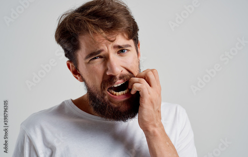 man with a beard wearing a white t-shirt health problems dental pain