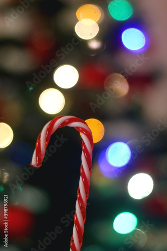 Candy cane decoration in front of a Christmas tree. Selective focus.