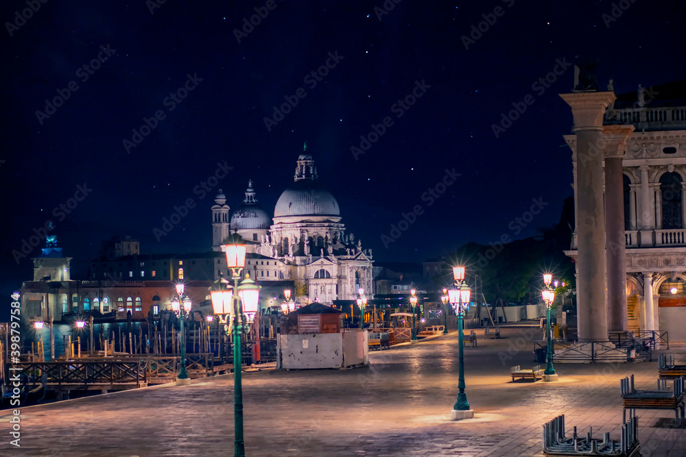 Basilica of Santa Maria della Salute in Venice seen at night with no one in the streets due to covid-19