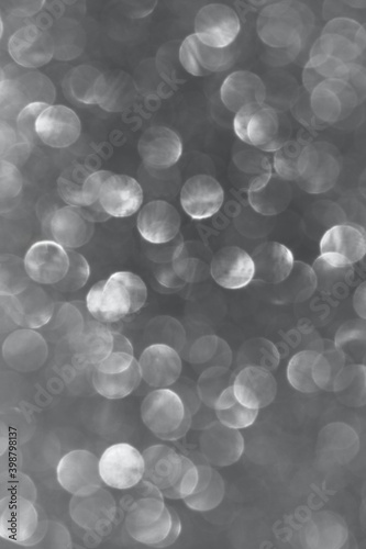Blurry image of gray lights, vertical view. Abstract backdrop, gray colors. 