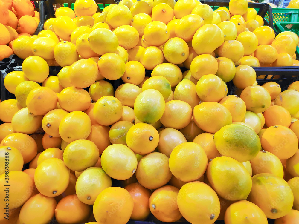 Bunch of fresh ripe lemons in boxes in supermarket close up Bunch of fresh ripe lemons in boxes in supermarket close up
