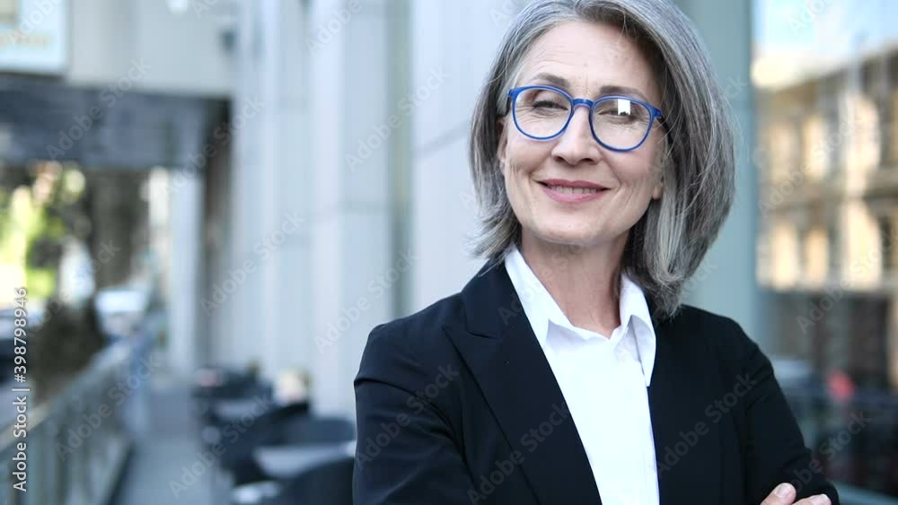 Mature gray haired woman boss with wrinkles in elegant suit looking at camera Mature gray haired woman boss with wrinkles in elegant suit looking at camera