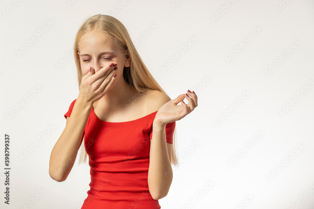 Teenage girl with blond hair and in a red dress sneezes Teenage girl with blond hair and in a red dress sneezes