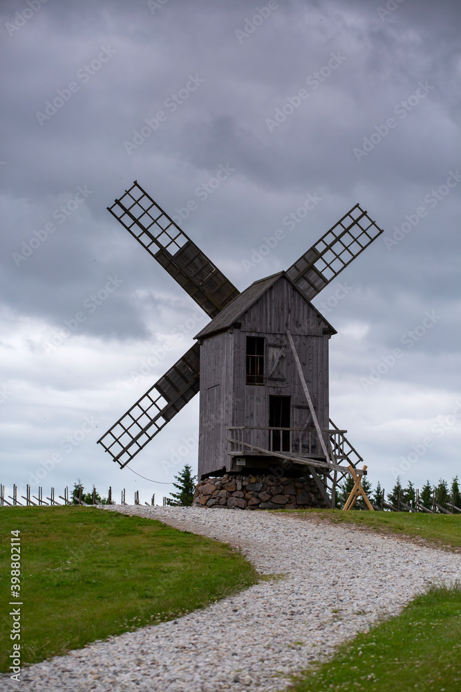 Historic old wooden windmill on a cloudy summer afternoon at Angla museum village at Saaremaa island, Estonia, Europe