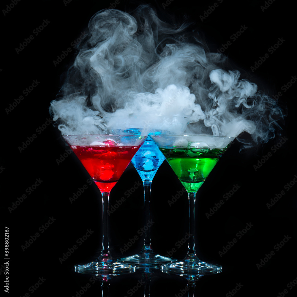 drei Martini Gläser mit farbiger Flüssigkeit aus denen weißer Rauch  aufsteigt Stock-Foto | Adobe Stock