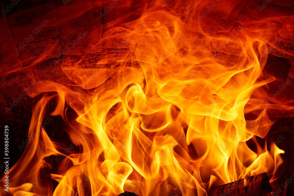 Burning fire flames on a dark background in a wood stove. Burning fire flames on a dark background in a wood stove.