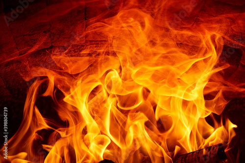 Burning fire flames on a dark background in a wood stove.
