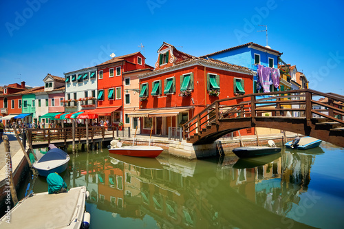 Burano lagoon famous traditional vivid colorful houses vibrant colors island tourism landmark cityscape. Sea canal with boats and bright paint facade old historic scenic place. Venice Italy