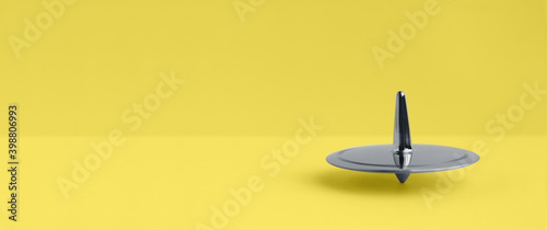 Canvas Print Metal Ultimate Gray spinning-top rotation on a yellow Illuminating background, 2
