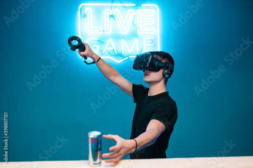 Valokuva A young man drinks energy while playing