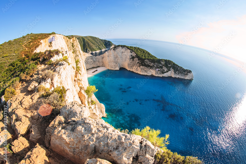 Aerial drone view of Navagio's famous beach in Zakinthos, Zante in Greece. A wreck of a boat lies on the beach as a tourist attraction, crystal clear sea 
