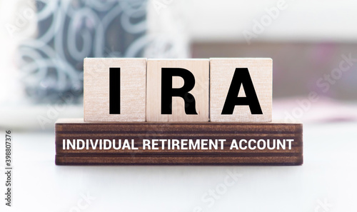 IRA individual retirement account word on wood cube block with blue background photo