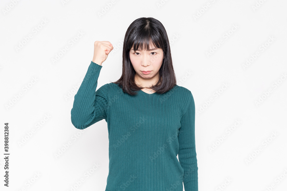 白背景の前で腕を組んで怒っている女性
