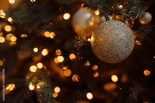 Close up of ball on Christmas tree with decoration and garland, under which a lot of presents. Prepare to winter holidays, New Year background concept