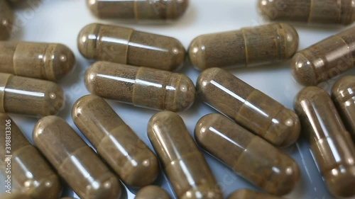 Clear capsule brown in color with a fine powder inside. Camera movement from left to right, close-up, real time, vegan, natural, dietary SUPPLEMENTS, pills photo