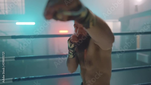 Boxer in the boxing gym. Bandages his hands. Sparring in the ring. Boxer jumping rope. Exercise with ropes. Round one. Fog in the ring. Zetsky sport. Beautiful backlight. World boxing champion.

 photo