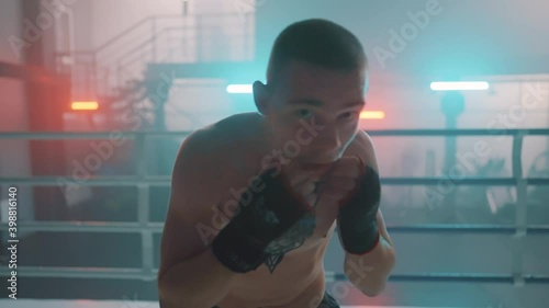 Boxer in the boxing gym. Bandages his hands. Sparring in the ring. Boxer jumping rope. Exercise with ropes. Round one. Fog in the ring. Zetsky sport. Beautiful backlight. World boxing champion.

 photo