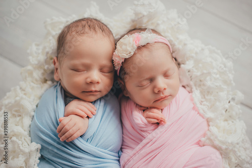 Twins are newborn brother and sister. Newborn girl and boy. Sleeping sweetly.