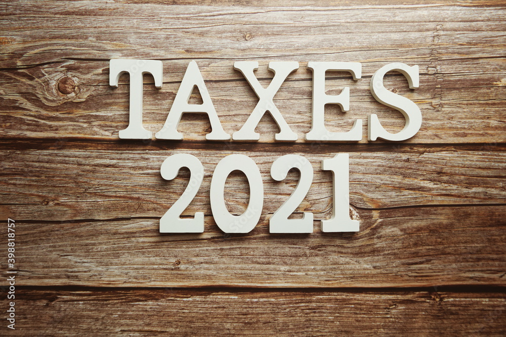 Taxes 2021 alphabet letter on wooden background Taxes 2021 alphabet letter on wooden background