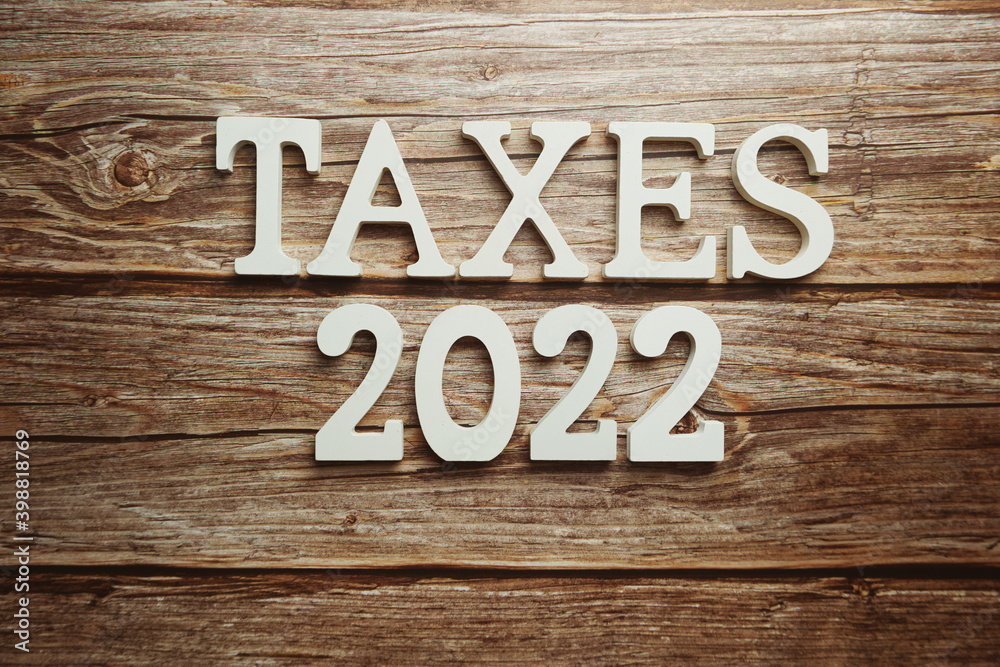 Taxes 2022 alphabet letter on wooden background Taxes 2022 alphabet letter on wooden background