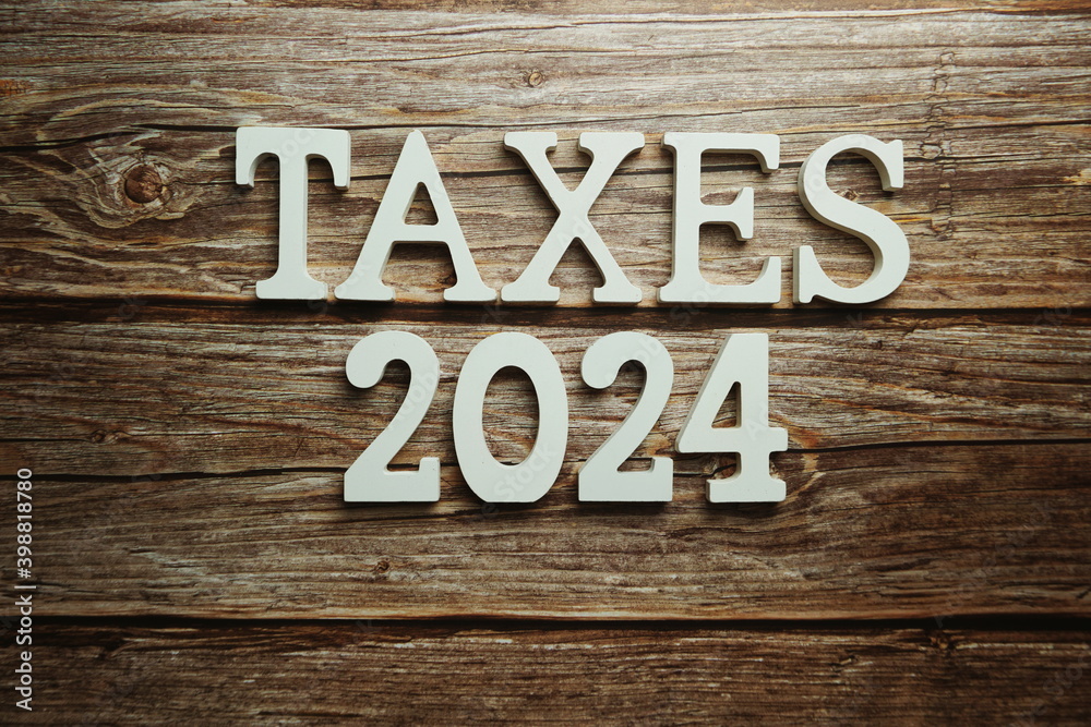 Taxes 2024 alphabet letter on wooden background Taxes 2024 alphabet letter on wooden background