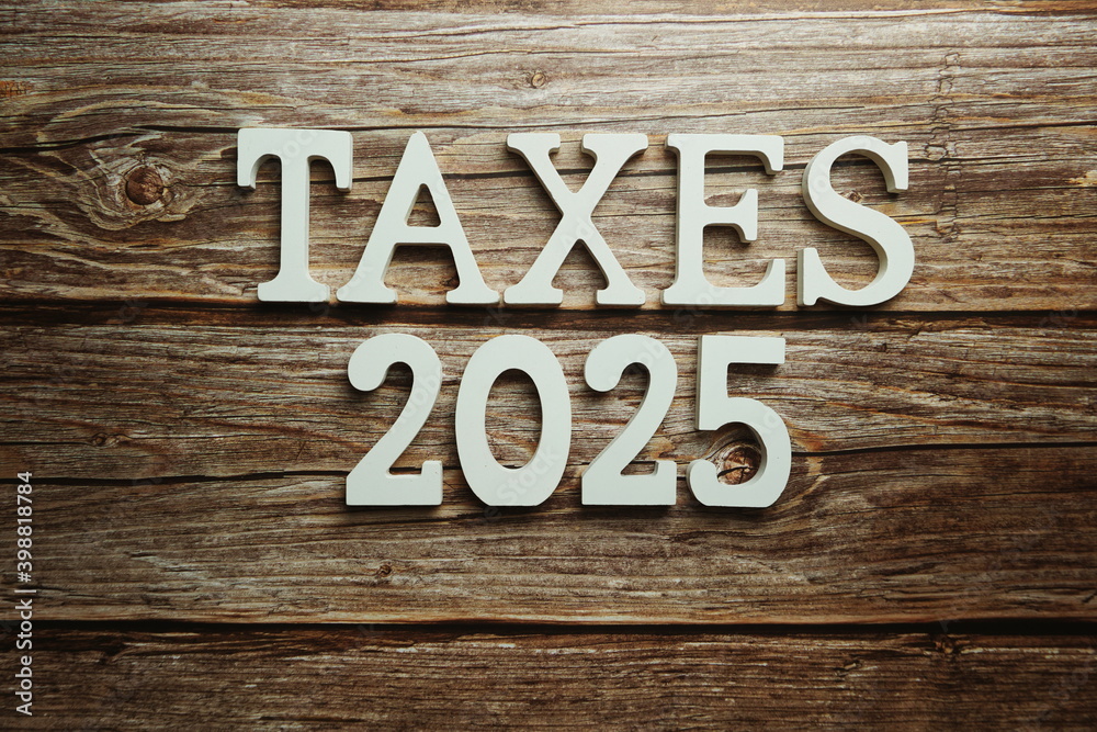 Taxes 2025 alphabet letter on wooden background Taxes 2025 alphabet letter on wooden background