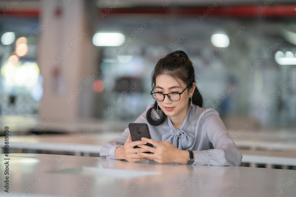 Young Asian beautiful woman using smart phone for business.