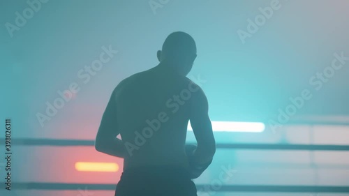 Boxer in the boxing gym. Bandages his hands. Sparring in the ring. Boxer jumping rope. Exercise with ropes. Round one. Fog in the ring. Zetsky sport. Beautiful backlight. World boxing champion.

 photo