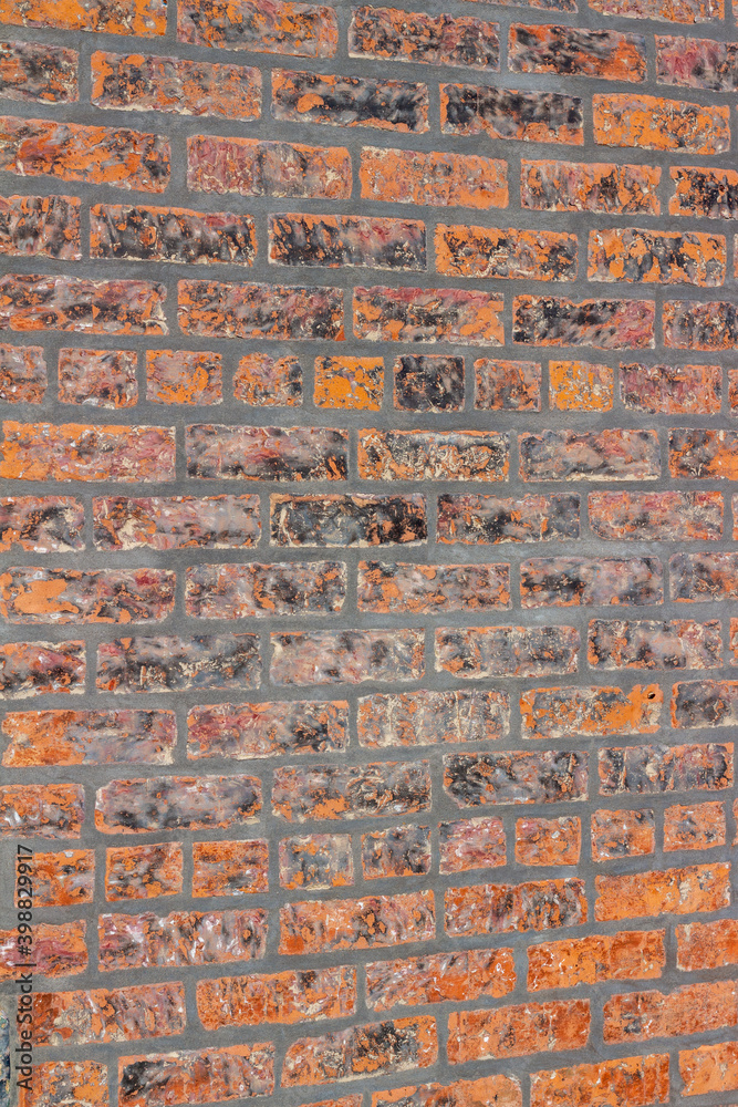 Full frame shabby chic vintage brick wall texture background, with fiery hot looking bricks in burnt shades of orange, red and brown