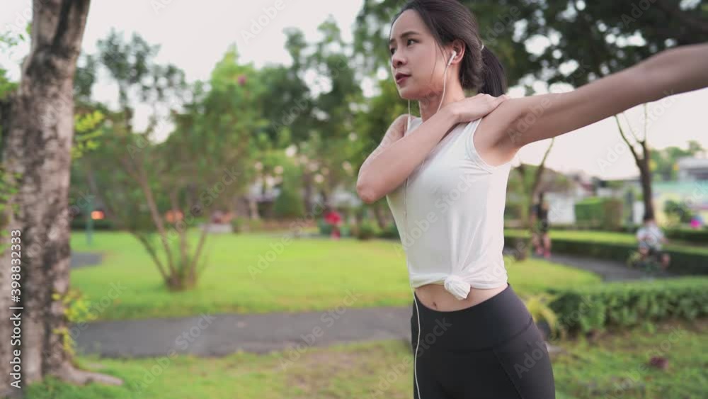 Asian active sporty female warm up stretching before exercise inside the park, fitness motivation, shoulder rotating back straight, health care insurance, outdoor activities, vitality wellness Asian active sporty female warm up stretching before exercise inside the park, fitness motivation, shoulder rotating back straight, health care insurance, outdoor activities, vitality wellness