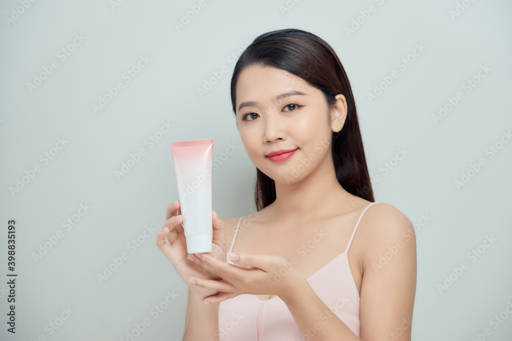 Beautiful Woman Face Portrait holding and presenting cream tube product Beautiful Woman Face Portrait holding and presenting cream tube product