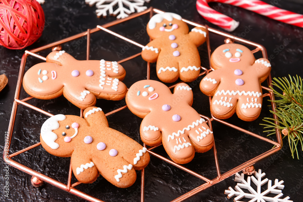 Cooling rack with tasty gingerbread cookies on dark background
