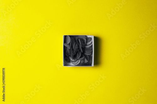 Gray confetti on yellow background - trendy colors of 2021. photo