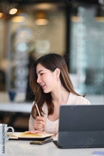 Front view of confident businesswoman holding a pen and thinking idea for a new project.